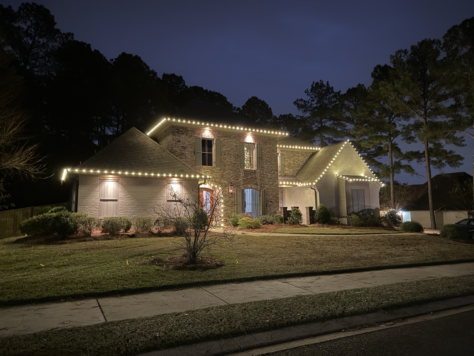 Warm white roofline Christmas lights on a two-story home
