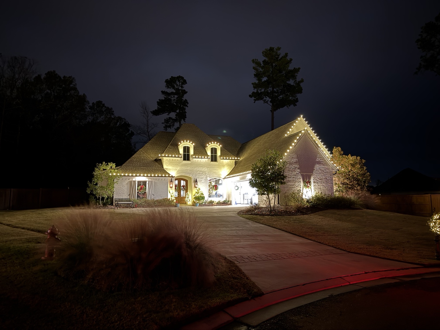 Warm white roofline Christmas lights on a brick home